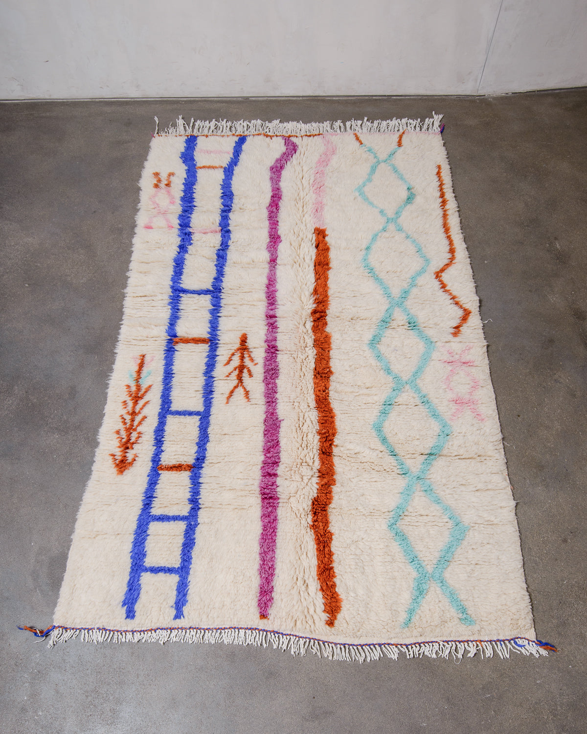 Berberlin Azilal rug made of fluffy wool, laying flat on a concrete floor.
